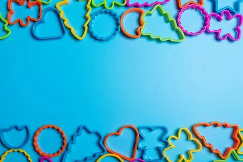 Multi-colored plastic molds of various shapes grouped on top and bottom for m Stock Photos