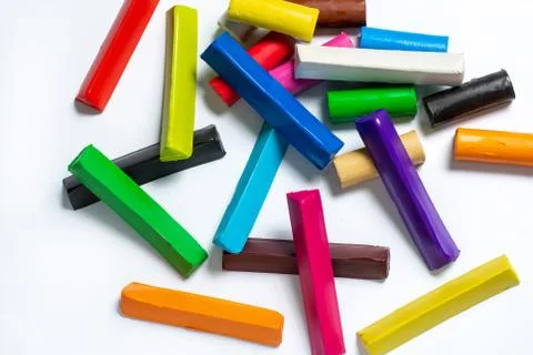 Multi-colored plasticine cubes lie a bunch on a white background. Stock Photos
