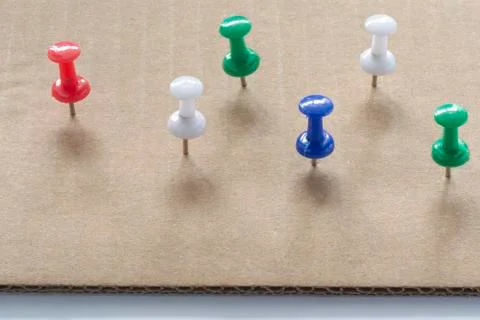 Multi colored Push Pins on White cardboard paper texture Background. Pushpins 스톡 사진