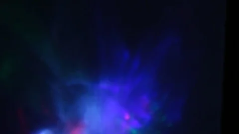 Multi-colored rays of light move randomly on a dark background Stock Footage 107469781