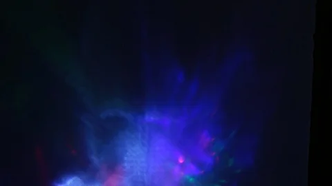 Multi-colored rays of light move randomly on a dark background Stock Footage 107469833