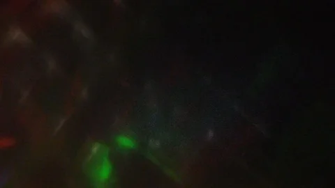 Multi-colored rays of light move randomly on a dark background. Video stock 124799651