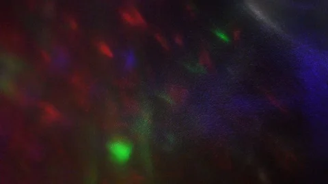 Multi-colored rays of light move randomly on a dark background. Video stock 124799712