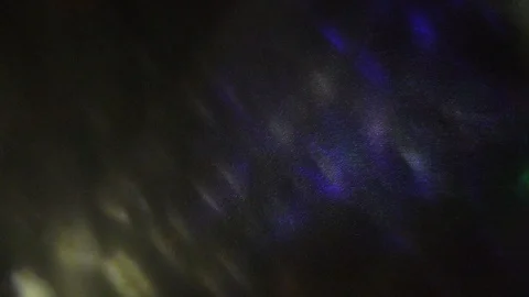 Multi-colored rays of light move randomly on a dark background. Video stock 124799752