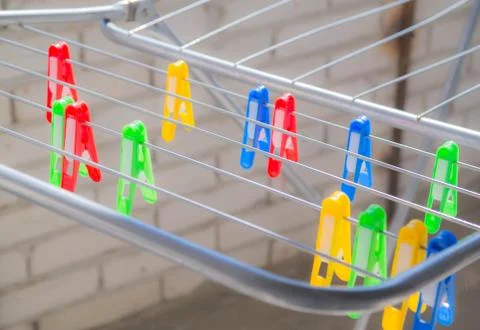 Multi-colored: red, yellow, green, blue clothespins on the clothes dryer Stock Photos