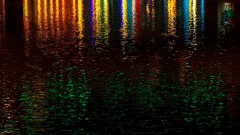 Multi-colored reflections on the river create a festive mood. Abstract. Stock Photos