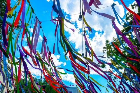 Multi-colored ribbons hang in the park on a holiday Stock Photos