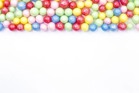 Multi-colored round glossy balls of sugar confectionery topping lie at the top Stock Photos