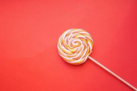 Multi-colored round lollipop on a bright red background. Foto stock