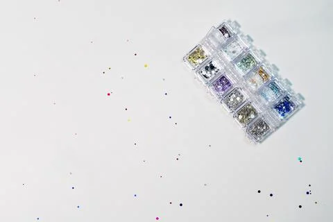 Multi-colored sequins, srazy, pebbles. Manicure design tools. Stock Photos
