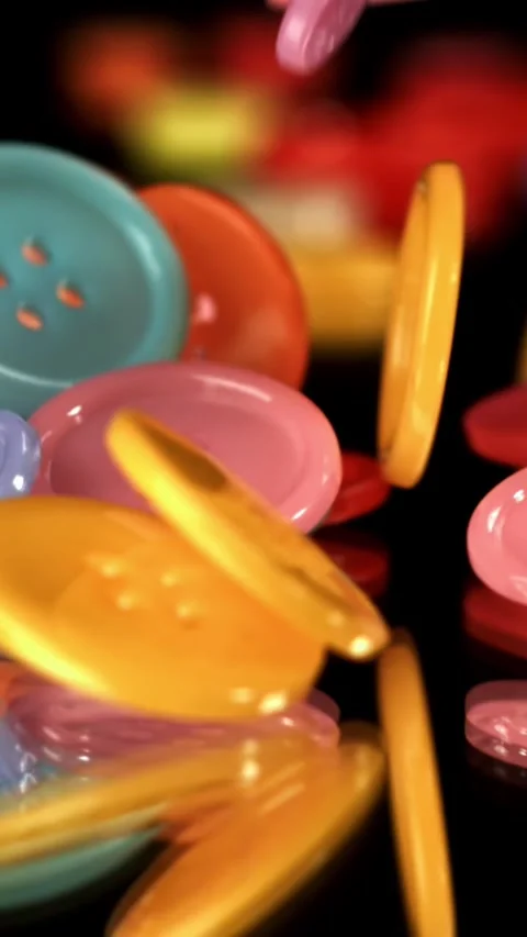 Multi-colored sewing buttons fall on the table. Filmed on a high-speed camera at Stock Footage 335364436