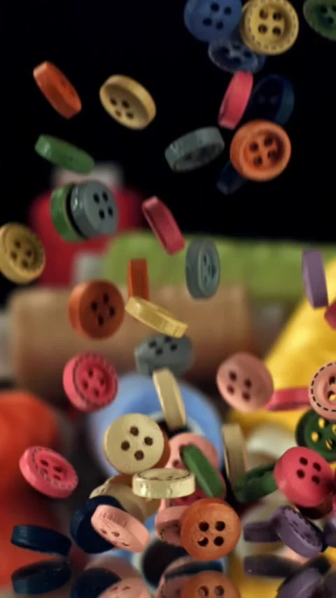 Multi-colored sewing buttons fall on the table. Filmed on a high-speed camera at Stock Footage 335367304