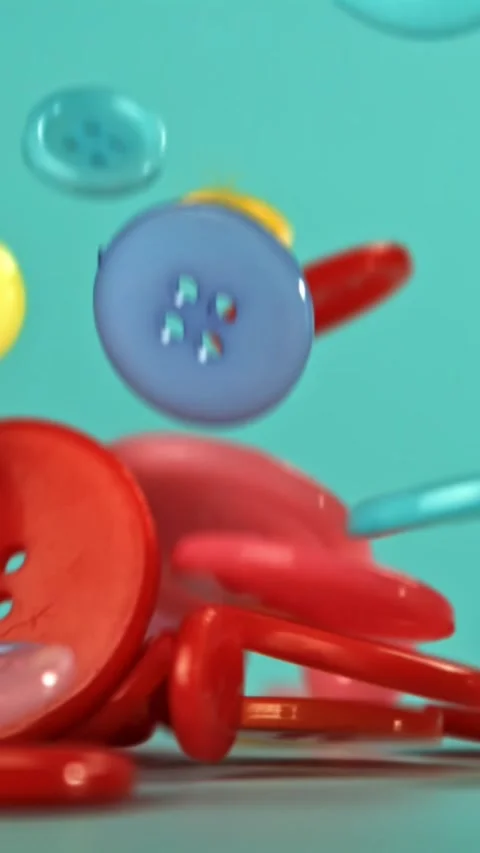 Multi-colored sewing buttons fall on the table. Filmed on a high-speed camera at Stock Footage 335367658
