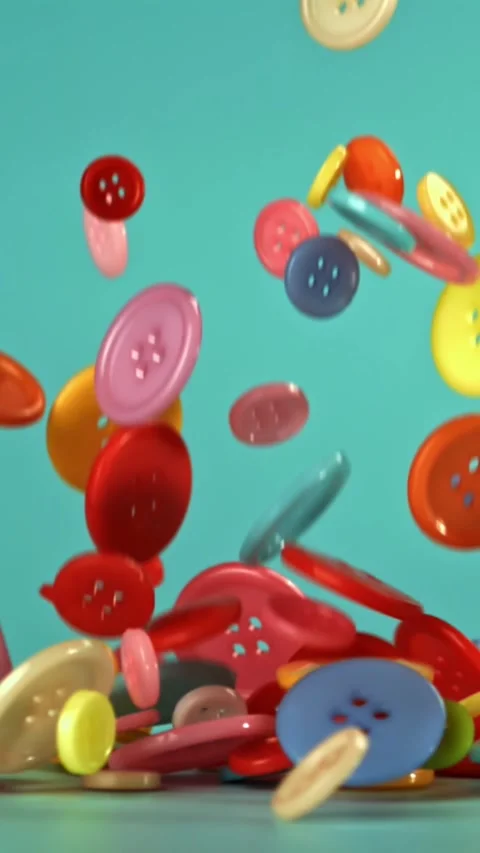 Multi-colored sewing buttons fall on the table. Filmed on a high-speed camera at Stock Footage 335368738