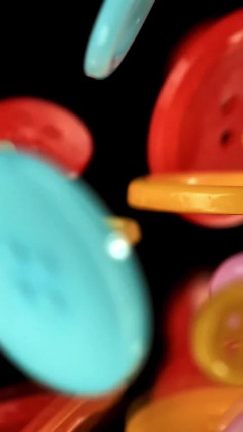 Multi-colored sewing buttons fall on the table. Filmed on a high-speed camera at Stock Footage 335370467