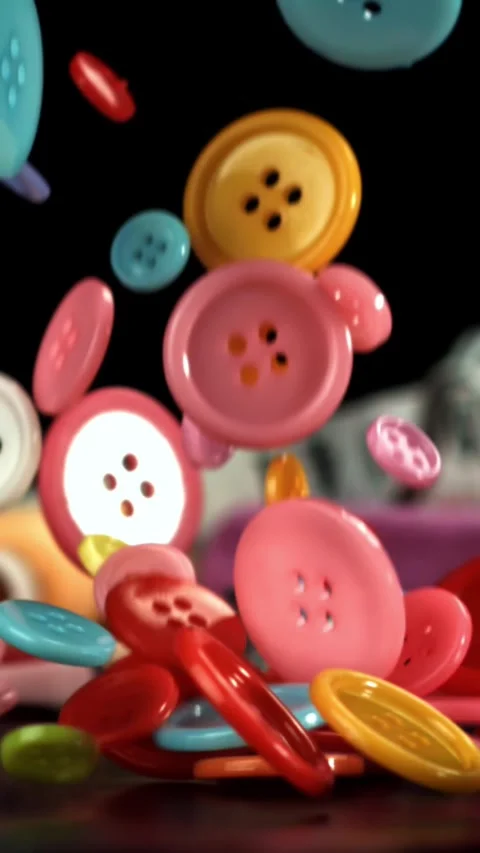 Multi-colored sewing buttons fall on the table. Filmed on a high-speed camera at Stock Footage 335371231