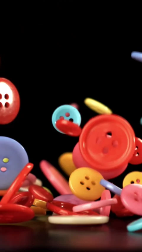 Multi-colored sewing buttons fall on the table. Filmed on a high-speed camera at Stock Footage 335372274