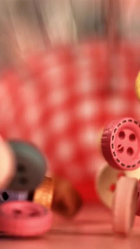Multi-colored sewing buttons fall on the table. Filmed on a high-speed camera at Stock Footage 335381076