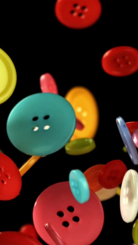 Multi-colored sewing buttons fly on a black background. Filmed on a high-speed Stock Footage 335384379
