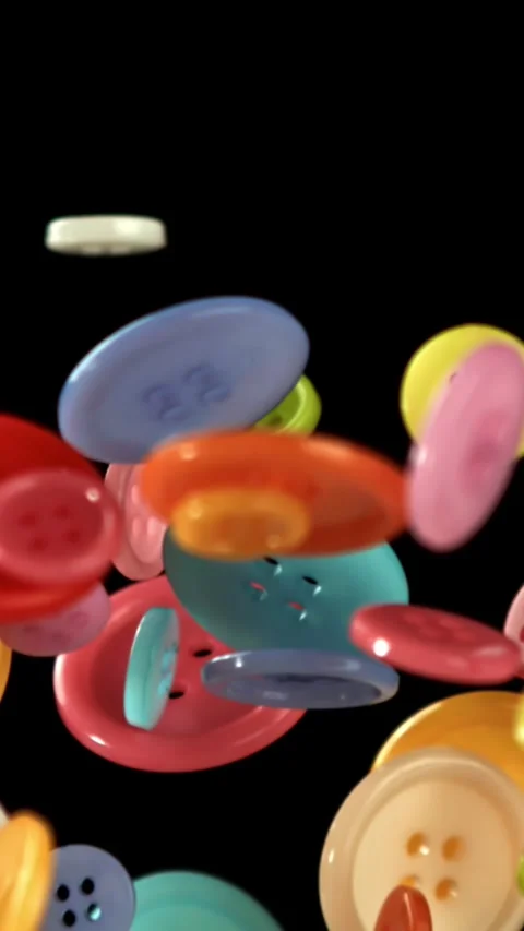 Multi-colored sewing buttons fly on a black background. Filmed on a high-speed Stock Footage 335385263