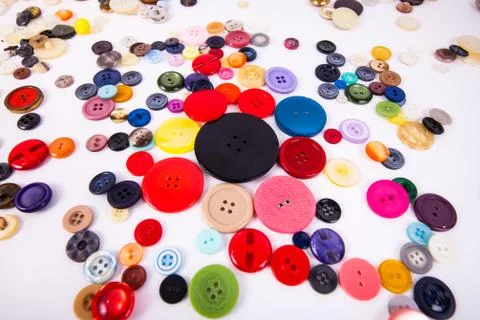 Multi colored sewing buttons scattered assorted sizes Stock Photos