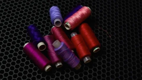 Multi-colored sewing threads on a dark background close-up from above Stock Photos