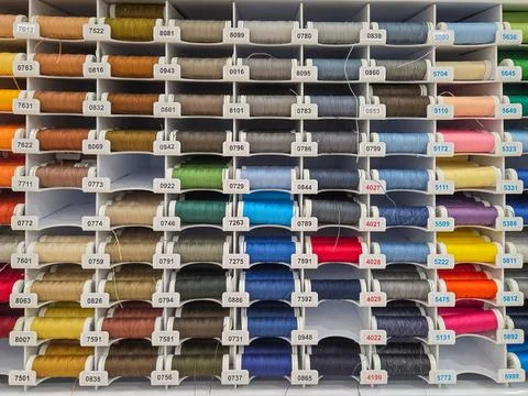 Multi-colored sewing threads on shop window. Hobby and needlework shop with coll Stock-Fotos