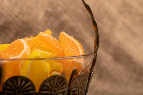 Multi-colored shaped marmalade lemon slices in a vintage vase, close-up, sele Stock Photos