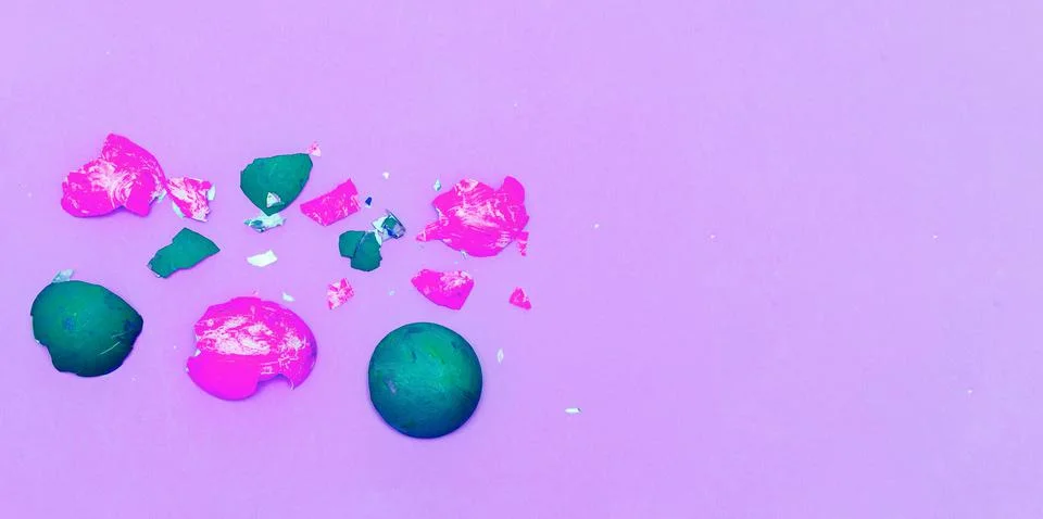 Multi-colored shells from chicken eggs on a pink paper background. Stock Photos