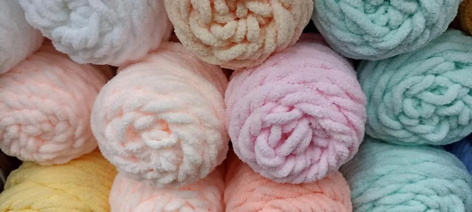 Multi-colored skeins of thread folded in a stack close-up Stock Photos
