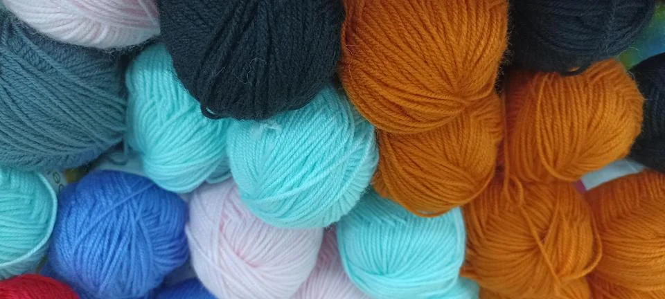 Multi-colored skeins of thread folded in a stack close-up Stock Photos