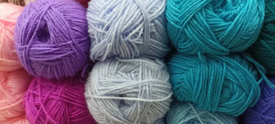 Multi-colored skeins of thread folded in a stack close-up Stock-Fotos