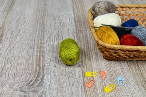 Multi-colored skeins of thread for knitting in a basket on a wooden background Stock Photos