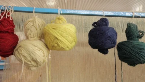 Multi-colored skeins of yarn hanging on the background of a loom. Stock Footage 120310146