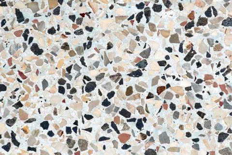 Multi-colored small flat stones are immersed in concrete. Foto stock