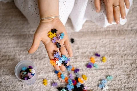 A multi-colored small puzzle set in a womans hands Stock Photos