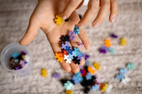 A multi-colored small puzzle set in a womans hands Foto stock