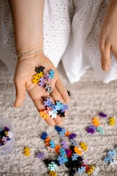A multi-colored small puzzle set in a womans hands Stock Photos