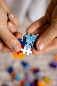 A multi-colored small puzzle set in a womans hands Foto stock