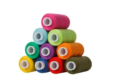 Multi-colored spools of sewing thread in the form of a pyramid on a white b.. Stock Photos