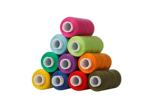 Multi-colored spools of sewing thread in the form of a pyramid on a white b.. Stock Photos