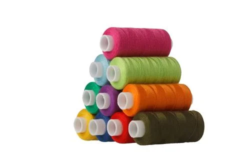 Multi-colored spools of sewing thread in the form of a pyramid on a white b.. Stock Photos