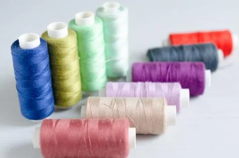 Multi-colored spools of sewing threads close-up. Craft and hobby concept. Stock Photos