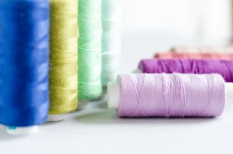 Multi-colored spools of sewing threads close-up. Craft and hobby concept. Stock Photos