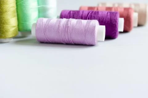 Multi-colored spools of sewing threads close-up. Craft and hobby concept. Stock Photos