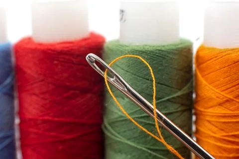 Multi-colored spools of thread close-up. Needle with thread. Seamstress or .. Stock Photos