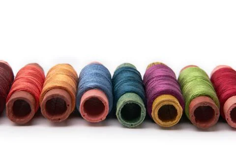 Multi-colored spools of thread stacked in a row Stock Photos