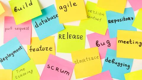 Multi-colored square stickers with terms from the IT field - release, bug, me Stock-Fotos