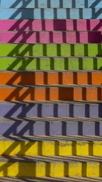 Multi-colored staircase with shadow from railing Stock Photos