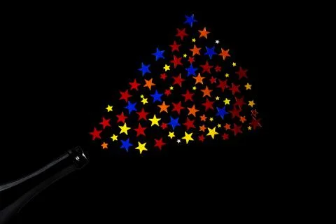 Multi-colored star confetti from a bottle of champagne. Concept for party fou Stock Photos
